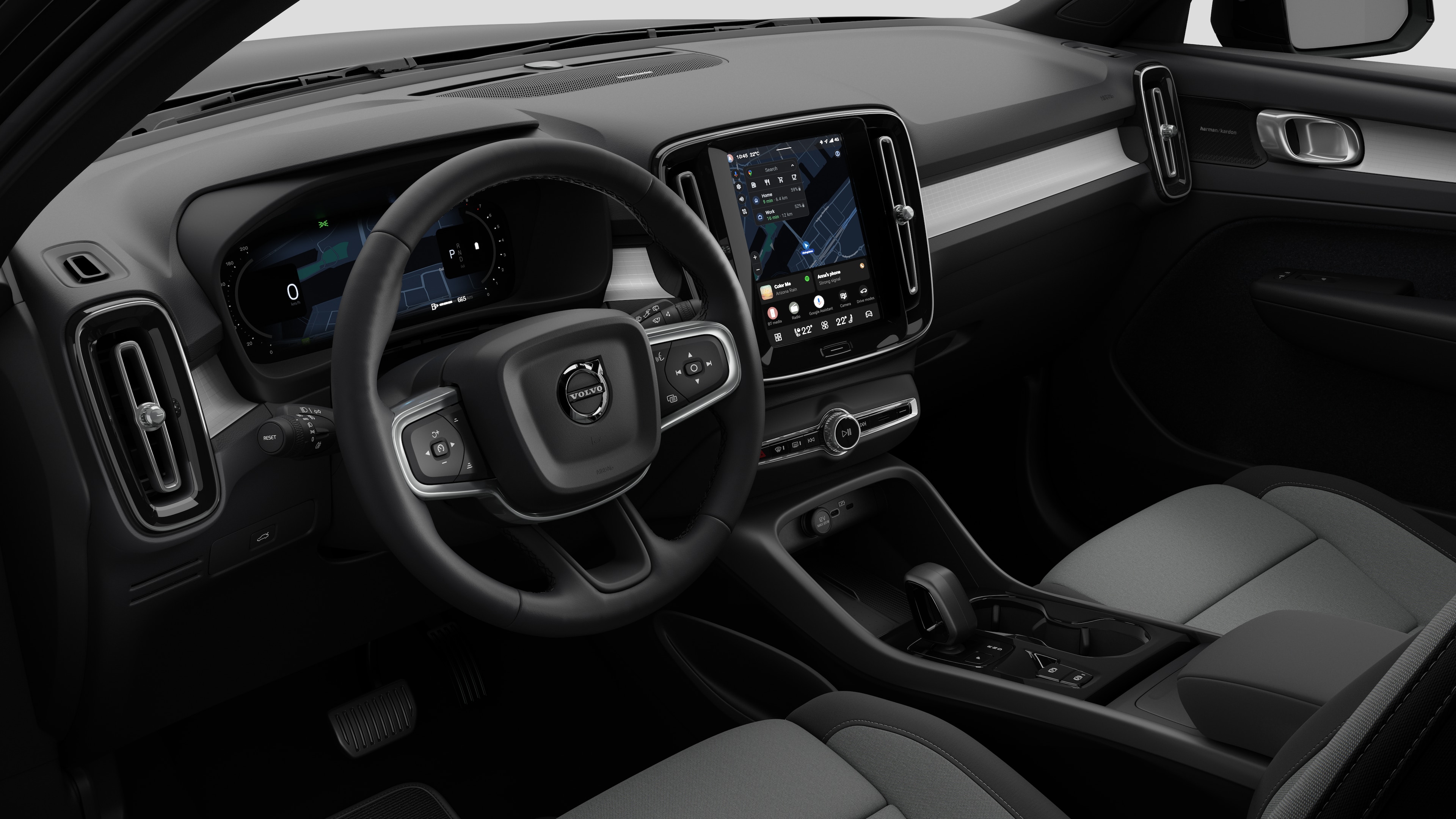 Vue intérieure d’une Volvo montrant le tableau de bord, le volant, la console centrale et l’écran d’affichage numérique dans un fond de studio uni.