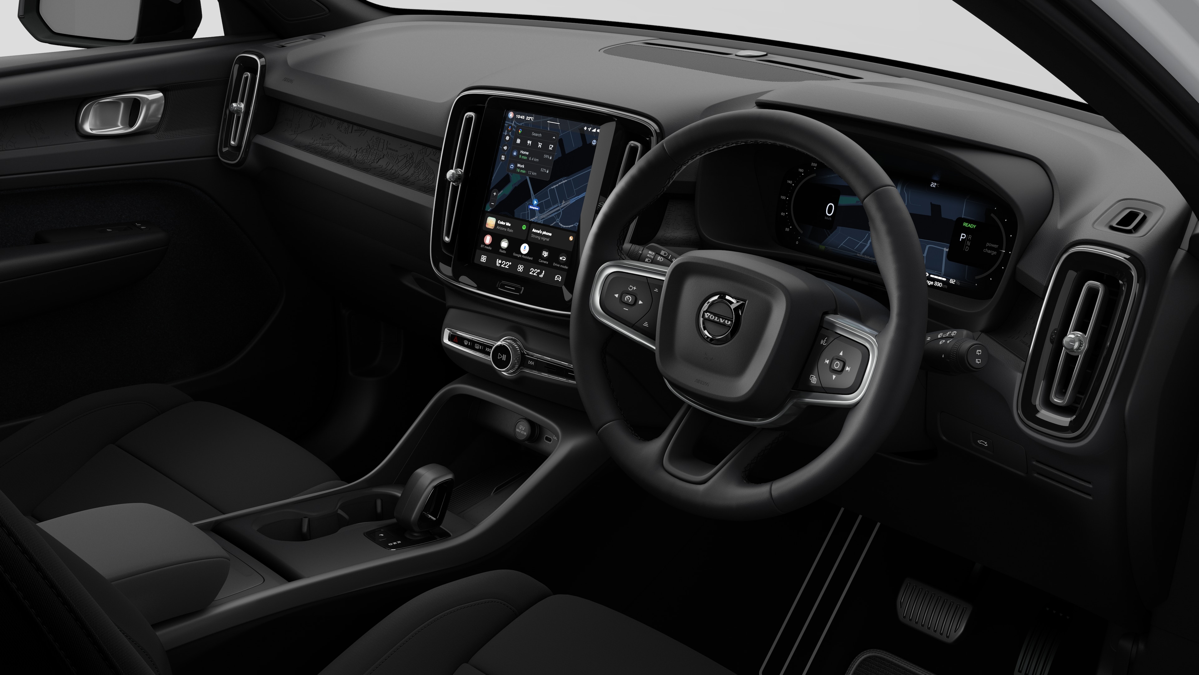 Interior view of a Volvo car showing the dashboard, steering wheel, center console, and digital display screen in a plain studio background.