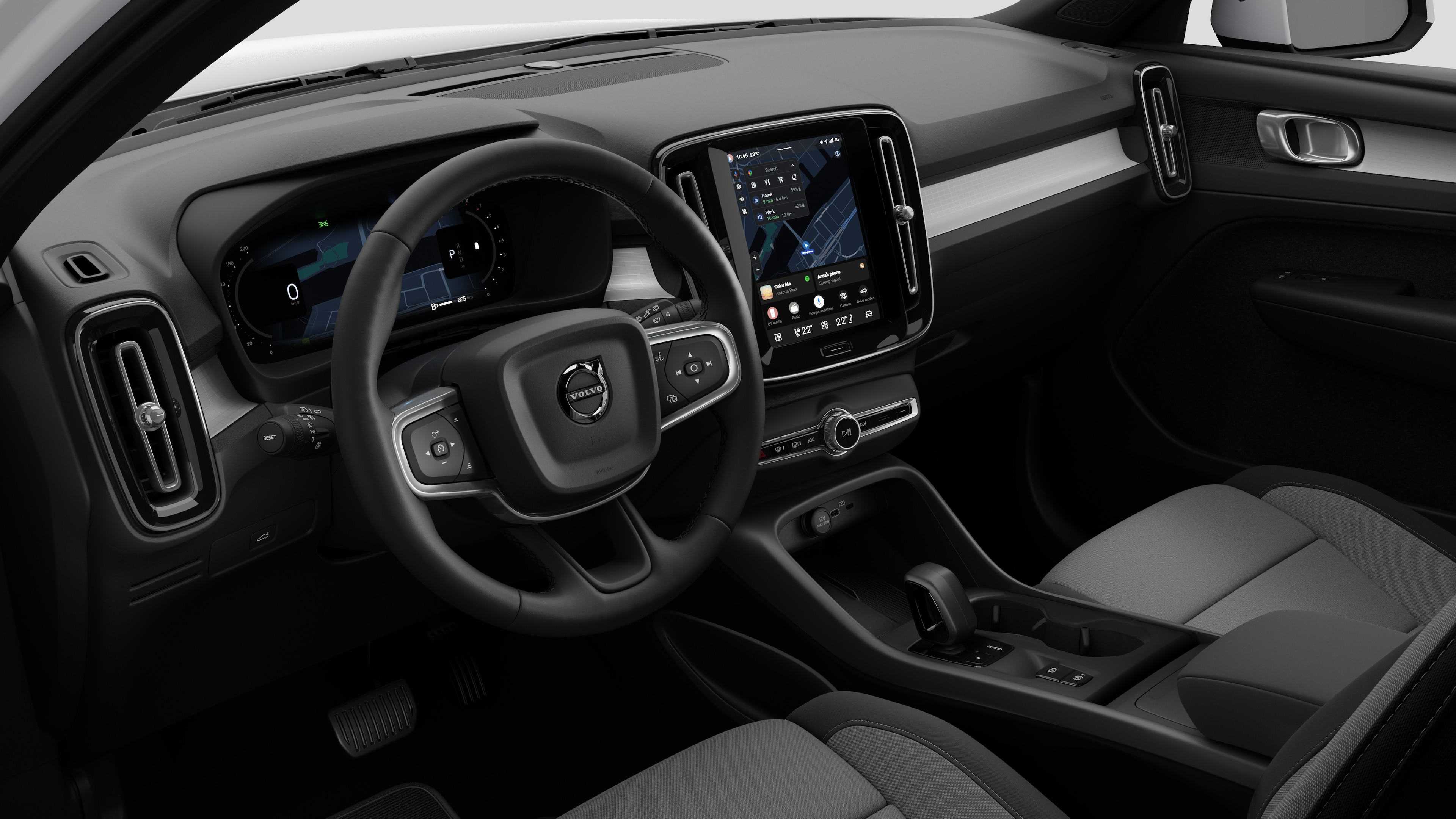 Vedere interioară a unei mașini Volvo, în care se arată tabloul de bord, volanul, consola centrală și ecranul digital de afișare, pe un fundal simplu de studio.