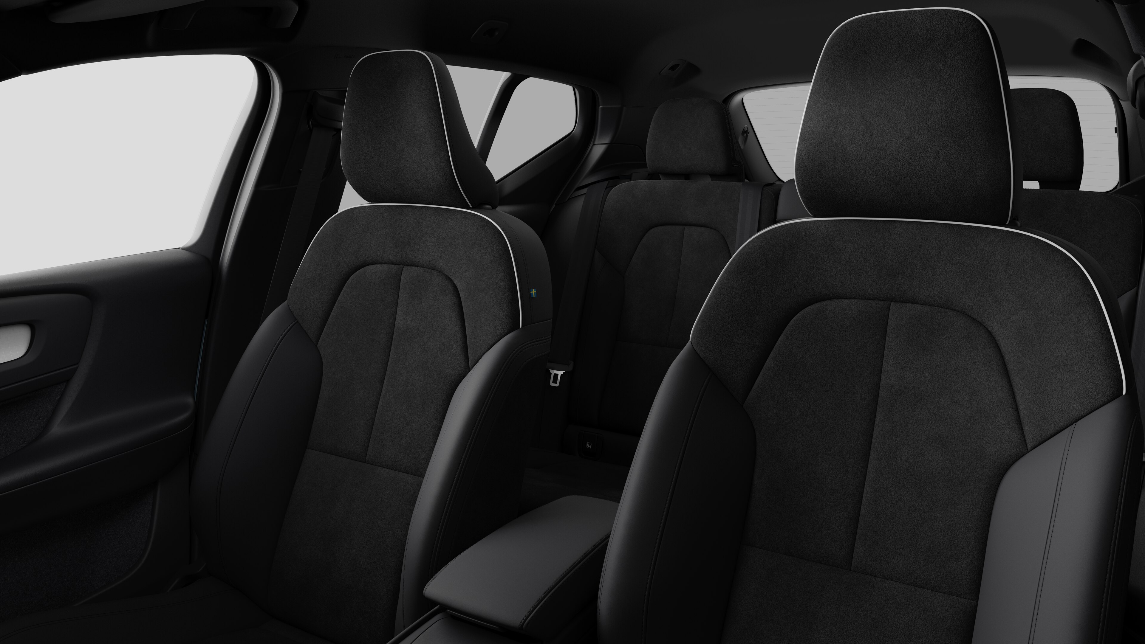 Το εσωτερικό ενός αυτοκινήτου Volvo όπου φαίνονται τα καθίσματα των πίσω επιβατών και η κεντρική κονσόλα σε απλό φόντο στούντιο.