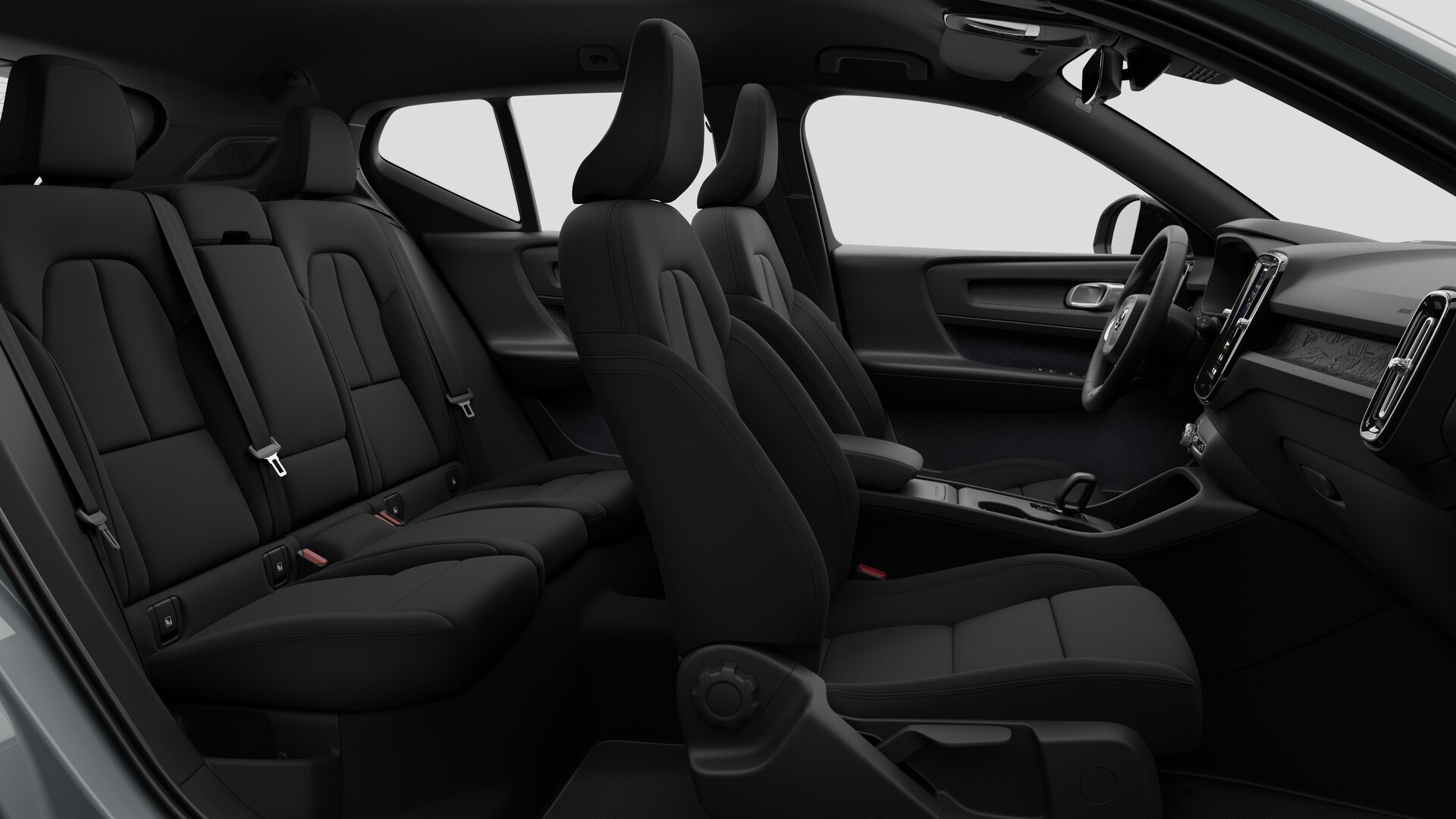 Vue latérale de l’intérieur d’une Volvo montrant les sièges avant, les sièges passager arrière, le volant, le tableau de bord et la console centrale, sur fond de studio.