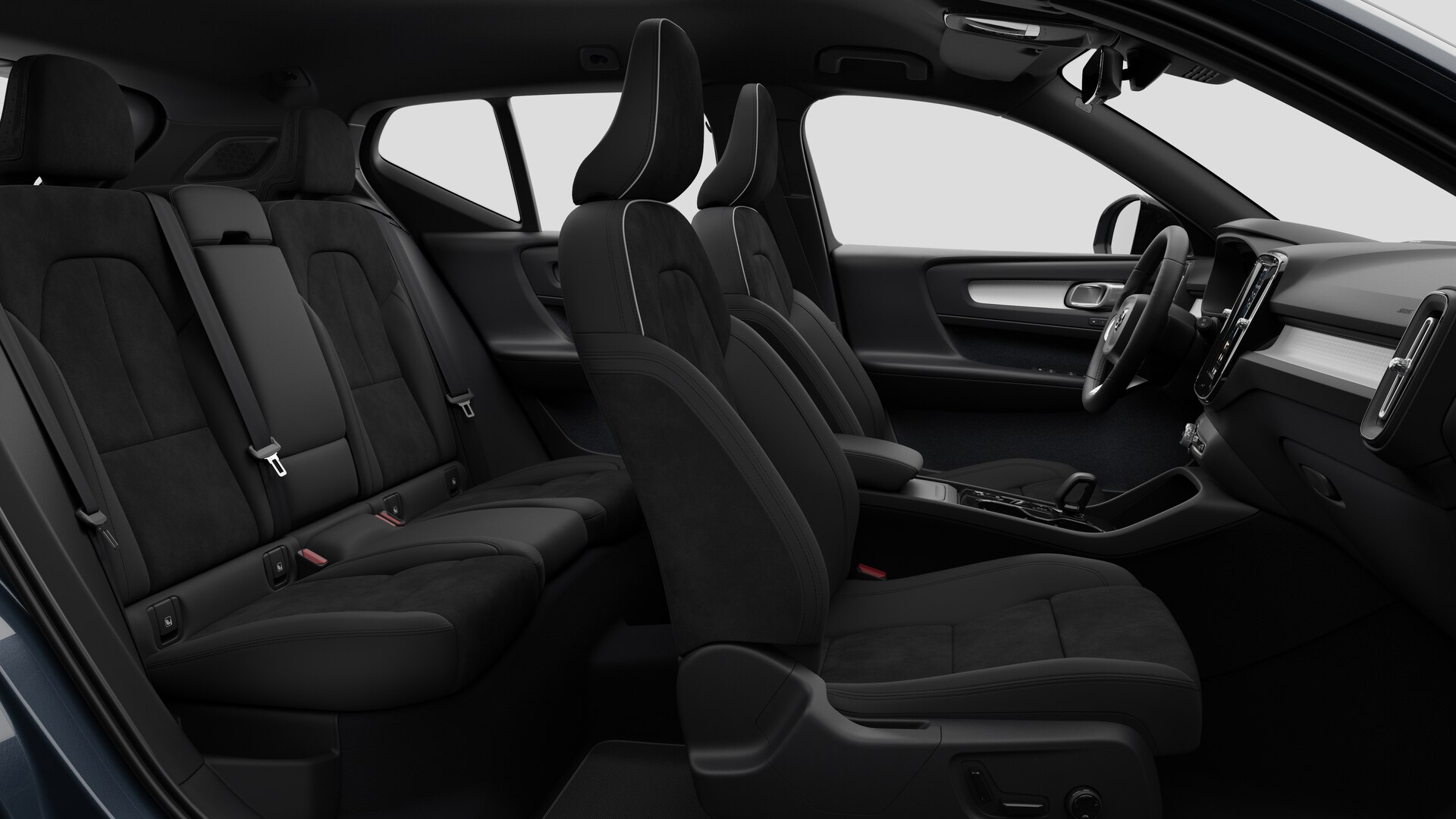 Vue latérale de l’intérieur d’une Volvo montrant les sièges avant, les sièges passager arrière, le volant, le tableau de bord et la console centrale, sur fond de studio.