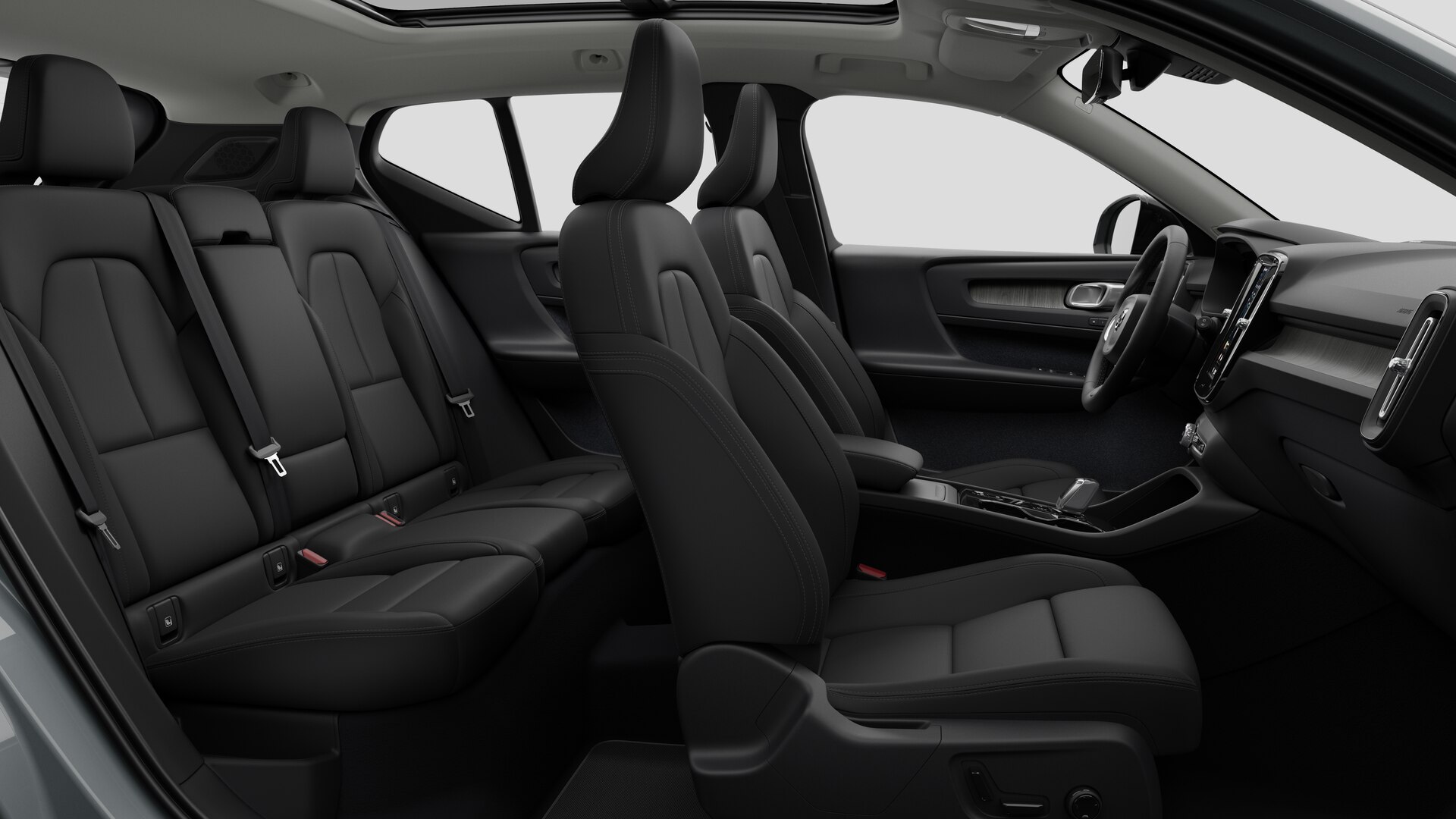 Vue latérale de l’intérieur d’une Volvo montrant les sièges avant, les sièges passager arrière, le volant, le tableau de bord et la console centrale, sur fond de studio.