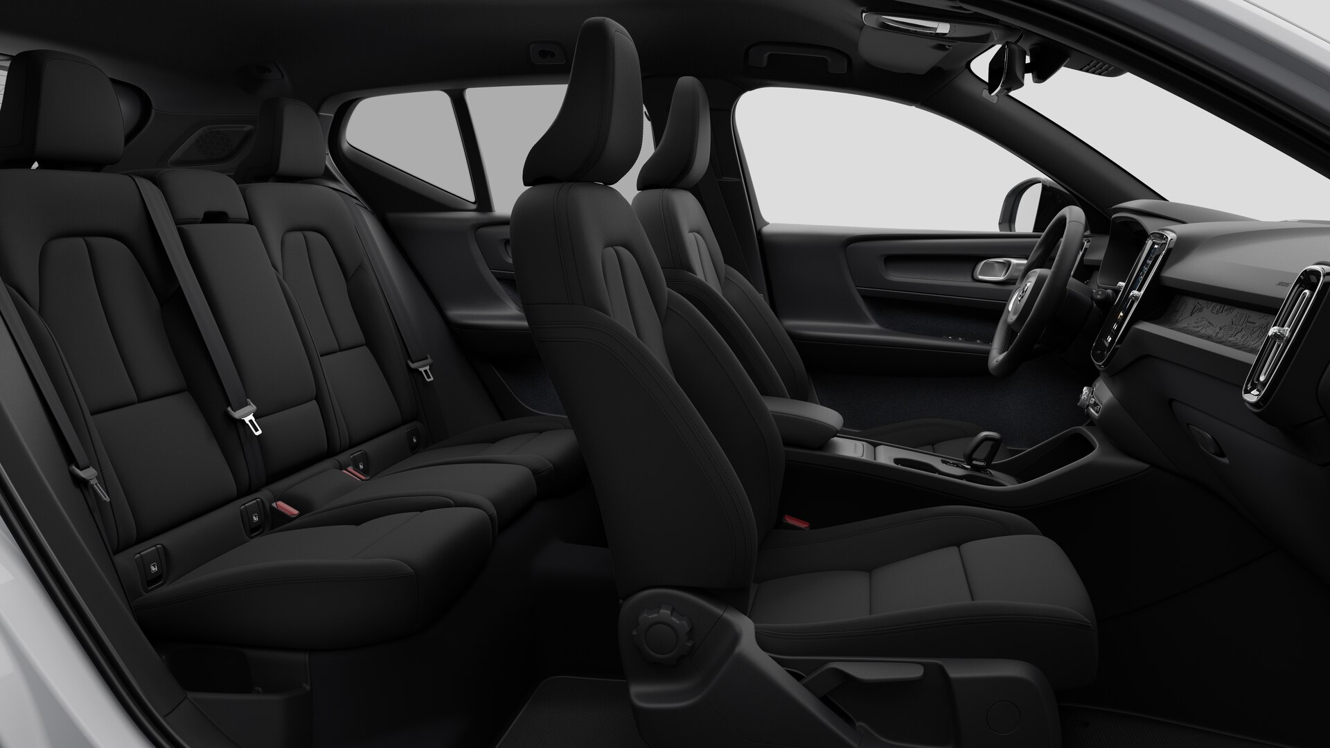 Vue latérale de l’intérieur d’une Volvo montrant les sièges avant, les sièges passager arrière, le volant, le tableau de bord et la console centrale, sur fond de studio.