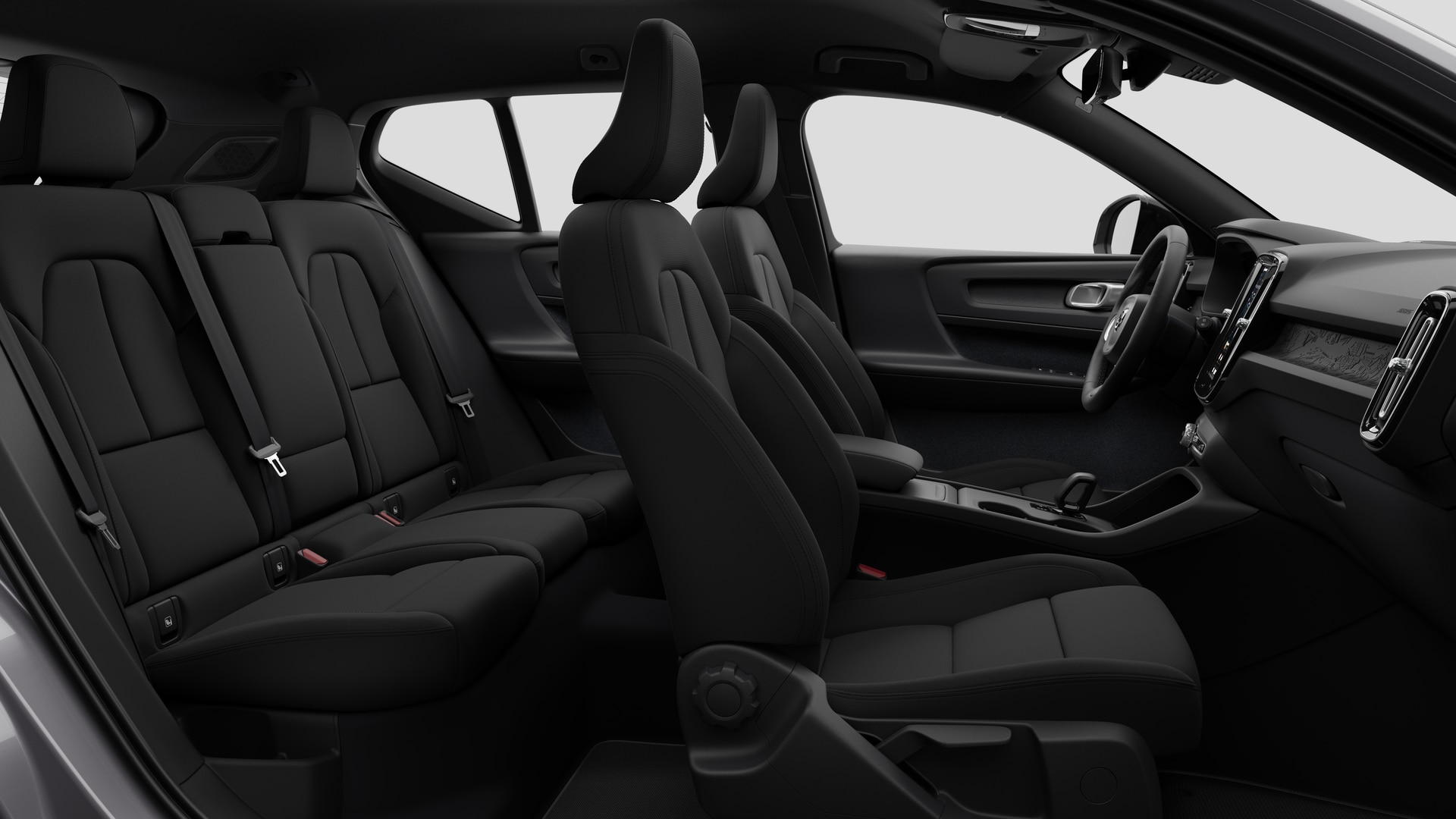Vue latérale de l’intérieur d’une Volvo montrant les sièges avant, les sièges passager arrière, le volant, le tableau de bord et la console centrale, sur fond de studio.