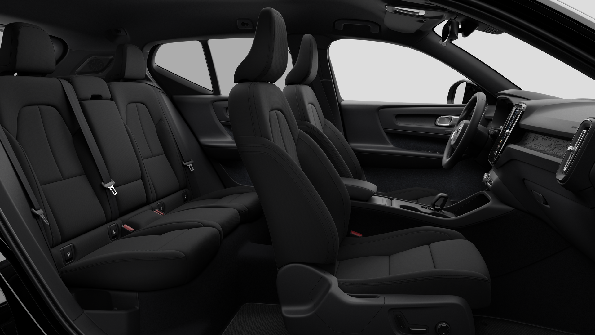 Vue latérale de l’intérieur d’une Volvo montrant les sièges avant, les sièges passager arrière, le volant, le tableau de bord et la console centrale, sur fond de studio.