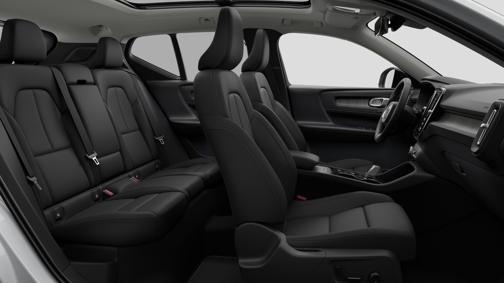 Vue latérale de l’intérieur d’une Volvo montrant les sièges avant, les sièges passager arrière, le volant, le tableau de bord et la console centrale, sur fond de studio.