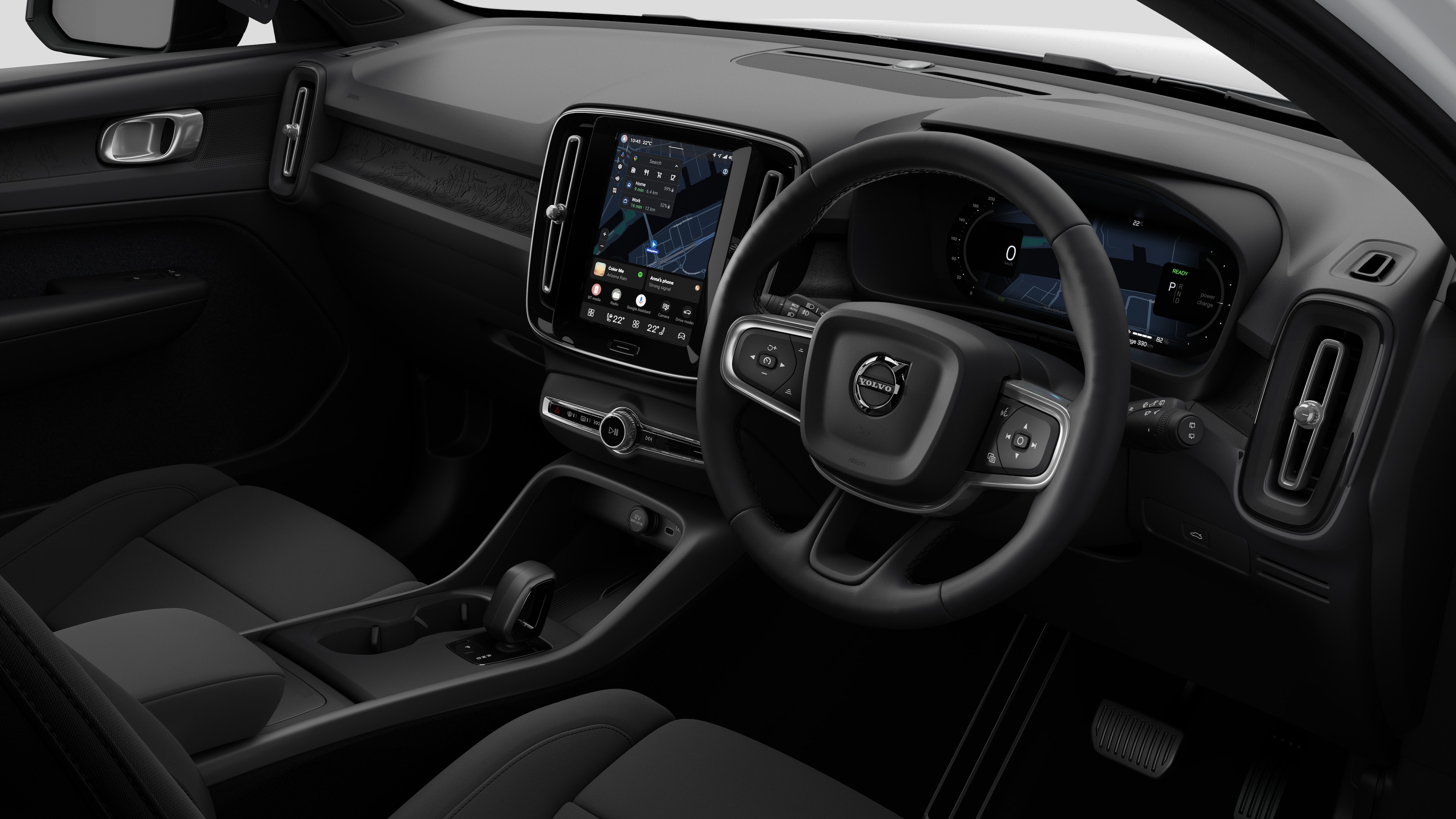 Interior view of a Volvo car showing the dashboard, steering wheel, center console, and digital display screen in a plain studio background.